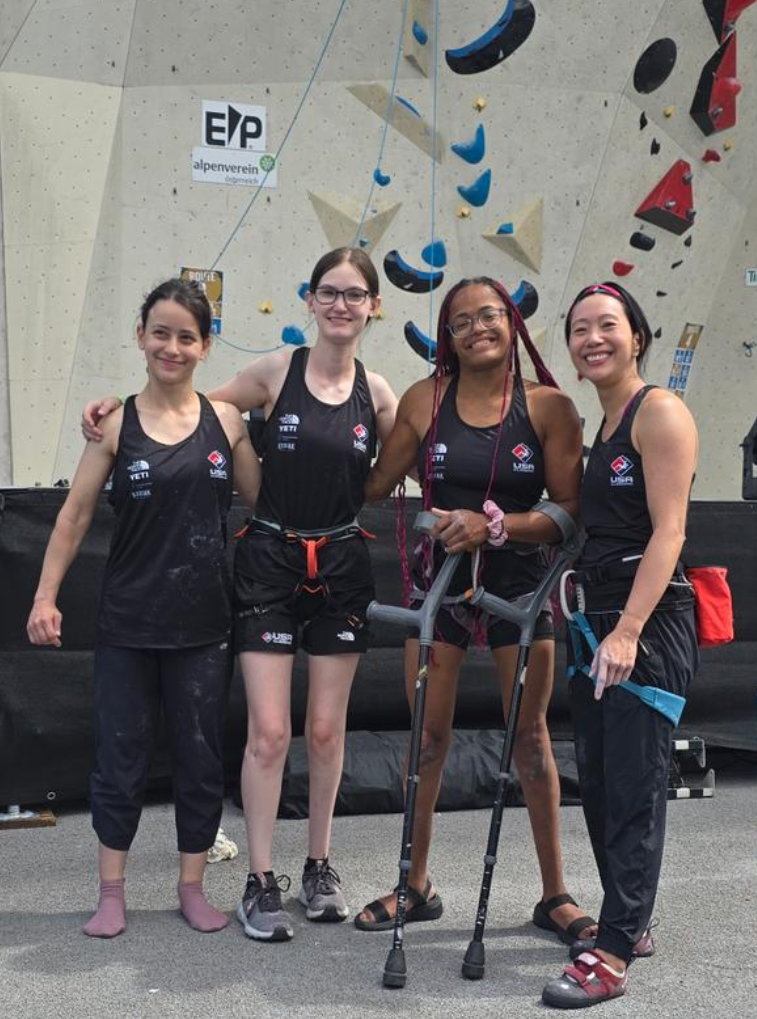 Photo of the USA women’s RP1 category standing in front of the main Kletterzenstrum competition wall. From left to right there’s Hannah, Jackie, myself, and Tiffany.
